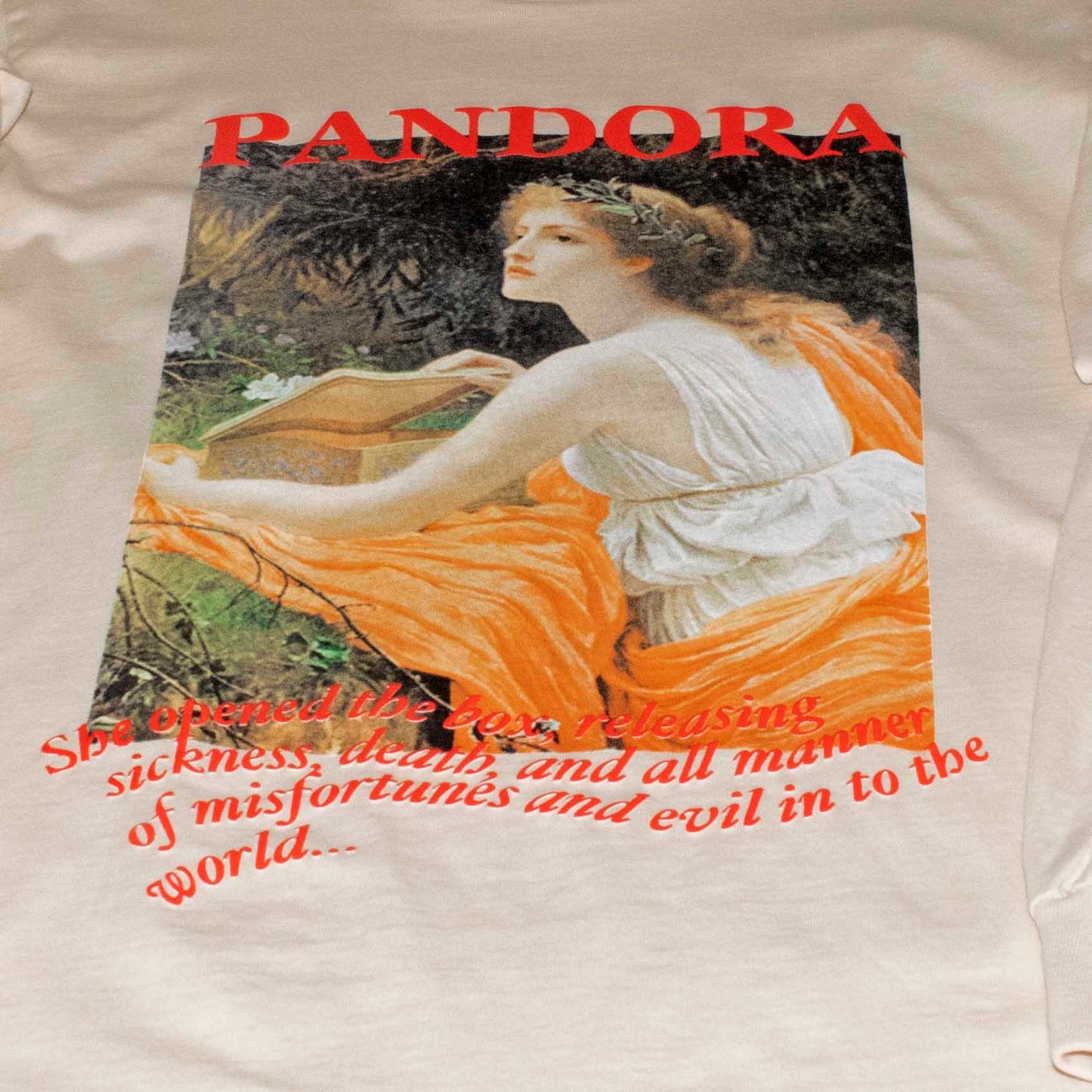 Full front photo of Altru Apparel Classic Pandora painting myth story screen printed graphic on front chest of long sleeve tan shirt with 3D puff ink accents.