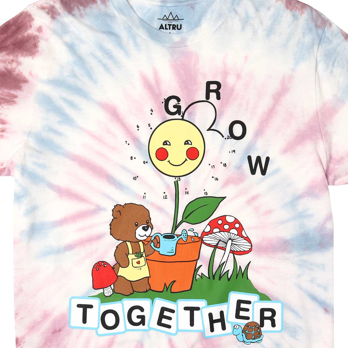 Front  detail of tie dye tee with graphic of a teddy bear garden with mushrooms and text saying grow together