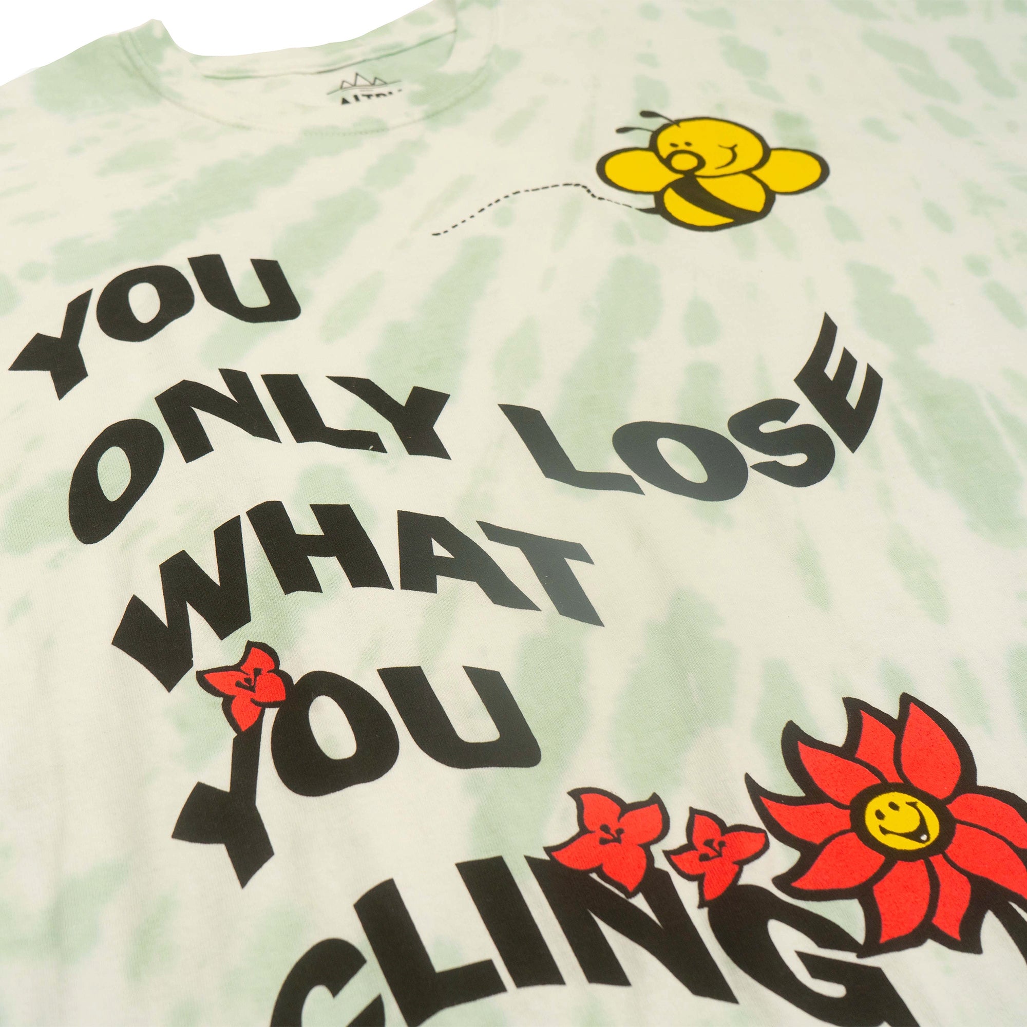 Only Lose What You Cling To Men's tee. Green and white tie dye with graphic of bee and flower and motivational text screen printed on front. Front detail photo.